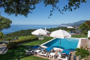 坎波罗索Villa Montefontane的一个带椅子和遮阳伞的游泳池以及大海