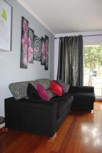 丰沙尔Uptown Madalenas的客厅配有黑色沙发和窗户