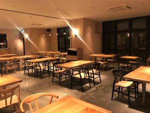 神户布伦扎酒店 的一间空餐厅,配有木桌和椅子