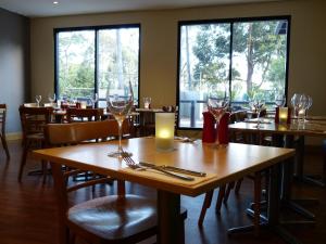 桑利宜必思索恩里酒店的餐厅设有桌子、酒杯和蜡烛