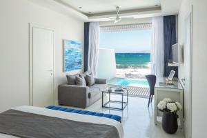 库基尼坎尼奥Knossos Beach Bungalows Suites Resort & Spa的酒店客房设有床、沙发和窗户。