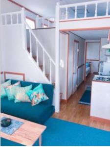 北谷町Mini Chula Inn的客厅设有蓝色的沙发和楼梯。