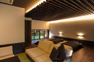 阿苏市尤诺雅道船酒店的一间卧室配有一张床和一张沙发