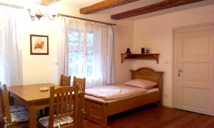 多克西U Leknínu的一间小卧室,配有一张床、一张桌子和一个窗户