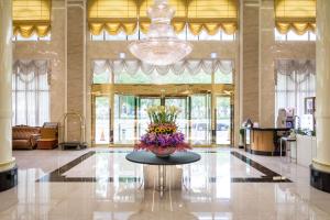 嘉义市嘉义皇品国际酒店的大堂设有一张桌子,上面有花瓶