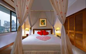吉隆坡吉隆坡克鲁斯酒店的一间卧室配有一张带心枕的床