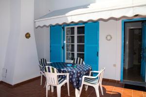 斯派赛斯Anemos的门廊上的一张桌子和椅子,门廊上设有蓝色的门