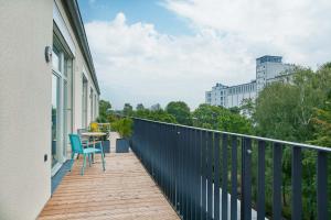 柏林Park Penthouses Insel Eiswerder的大楼内的阳台配有桌椅