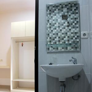 雅加达Rumah99的浴室设有水槽和墙上的镜子