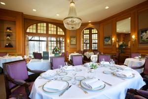 科内勒库奈尔磨坊酒店的一间设有白色桌子和紫色椅子的用餐室