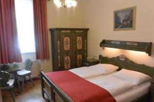 萨尔茨堡阿德霍夫酒店的一间卧室配有两张床和一张桌子及一张桌子。