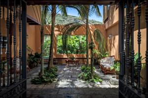 伊科德洛斯维诺斯圣马科斯标志酒店的一个带棕榈树和沙发的户外庭院