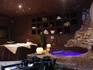 巴尼奥迪罗马涅托斯科罗马尼奥洛酒店的一间带石头壁炉和热水浴池的餐厅