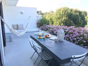 特罗亚Soltroia Beachouse的紫色花卉庭院里的蓝色桌子和椅子