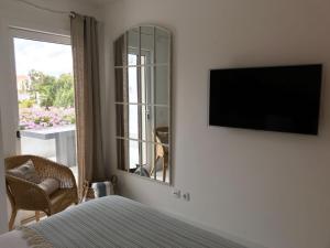特罗亚Soltroia Beachouse的一间卧室配有电视、一张床和镜子