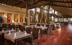 科尔巴非洲玉塔拉索度假村的一间在房间内配有桌椅的餐厅