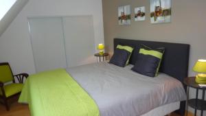 布雷斯特brest chambres d'hôtes的一间卧室配有一张带蓝色和绿色枕头的床