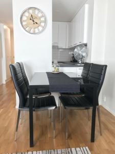 波里Antintorni Suite 17的厨房配有黑色的桌子、椅子和时钟