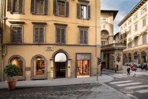 佛罗伦萨伊莎贝拉室友酒店的街上的一座建筑,街上的人在街上行走