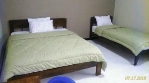 BajawaCinnamon Guest House的两张床铺位于带椅子的房间