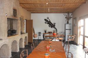 哈坦柏斯Cheetah Lodge Guest House的一间带桌子和壁炉的用餐室