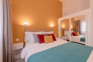 马斯帕洛马斯维斯塔塞里娜俱乐部酒店的一间卧室配有两张带红色和黄色枕头的床