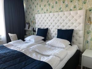 松德比尚德比霍尔莫斯斯洛特酒店的一张配有白色床单和蓝色枕头的大床