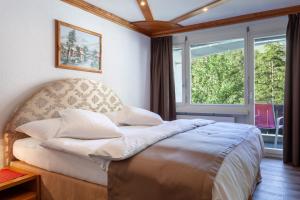 采尔马特博里瓦奇酒店的一张位于带大窗户的房间内的床铺