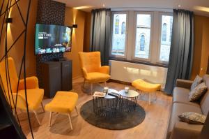 拉罗什-阿登4 rue du Balloir的客厅配有黄色椅子和电视