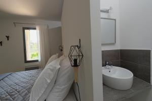 Saint-Jean-de-CucullesLes Lodges du Pic的白色卧室设有床铺和水槽
