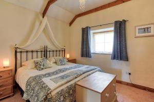 韦德布里奇Tregolls Farm Cottages的一间卧室设有一张大床和一个窗户。