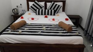 哈伯勒内Habarana New Star Homestay的一张配有黑白毯子和枕头的床