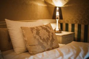 Nowe Kramsko维亚别墅酒店的一张带枕头的床和一张桌子上的台灯