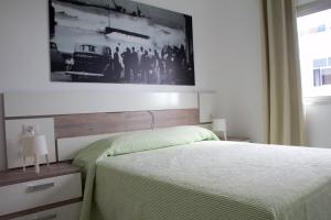 罗萨里奥港Apartamentos Tao Laia的卧室配有一张挂在墙上的床铺