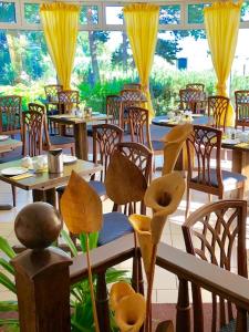青斯特Hotel-Marks-Garni的餐厅设有桌椅和黄色窗帘