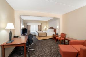 夏洛特温盖特温德姆夏洛特机场酒店的配有一张床和一张书桌的酒店客房