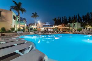 马斯帕洛马斯维斯塔塞里娜俱乐部酒店的一个带椅子的大型游泳池和一间酒店