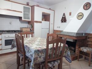 AmaroniCasa Elena的厨房配有桌椅和壁炉。