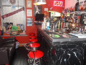 布莱克浦百利酒店 的一间酒吧,设有红色的墙壁和红色的凳子