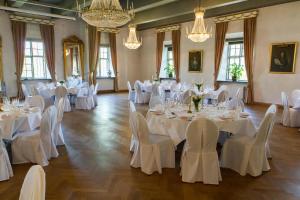 松德比尚德比霍尔莫斯斯洛特酒店的配有白色桌椅和吊灯的房间