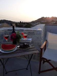 皮特斯迪亚Kritikies Elaia的阳台上的桌子和两杯葡萄酒