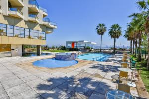 尼泰罗伊Hotel Orizzonte Niteroi by Atlantica的享有带游泳池和棕榈树的建筑的景致