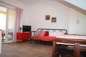 维甘Apartman Luka的一间卧室配有一张床和一张红色的沙发