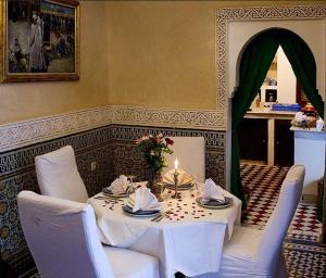 马拉喀什Riad Bab Chems的一张桌子,上面有白色的桌布和蜡烛