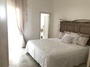 马鲁焦I quartini的卧室配有白色的床和木制床头板