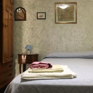 多尔加利Casa Aurora的一间卧室配有一张床,上面有两条毛巾