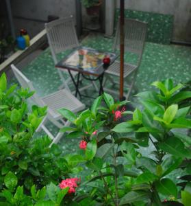 河江洪邵2号酒店的庭院里种着鲜花,配有两把椅子和一张桌子