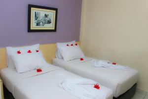 北干巴鲁Sabrina Paninsula的红色弓的房间里设有两张床