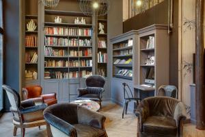 贝桑松西塔代勒贝斯特韦斯特酒店的图书馆配有椅子和书架