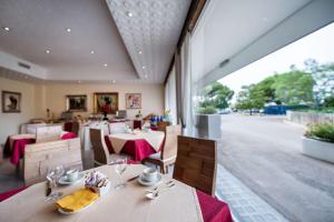 莫杜尼奥Hotel HR的餐厅设有桌椅和大窗户。